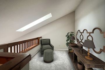 Springfield townhouse for rent - A living room with a grey armchair and a wooden table with a lamp on it.