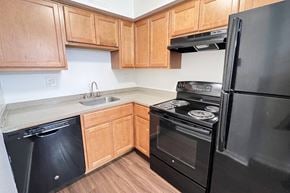Blue Ash townhouse for rent - a kitchen with black appliances and wooden cabinets at Walnut Creek Townhomes, Cincinnati, 45236
