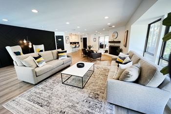 A living room with couches and a coffee table in front of a fireplace