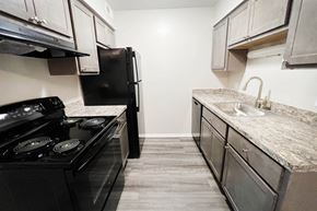 Franklin apartment for rent - a kitchen with white cabinets and black appliances at Crown Ridge Apartments, Ohio