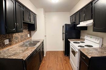 A kitchen with black cabinets and white appliances