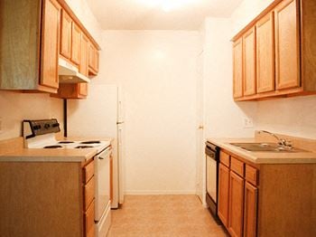 A kitchen with wooden cabinets and white appliances
