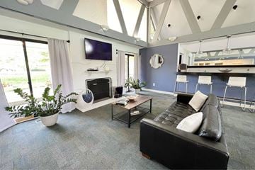 Miamisburg townhouse for rent - A living room with a black leather couch and a flat screen TV mounted on the wall.