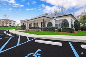 Mobile apartment for rent - A parking lot with a handicap parking sign in front of a building.