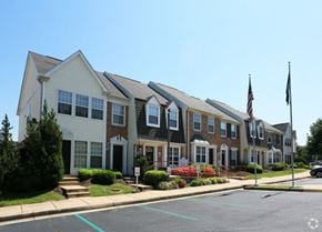 Manassas apartment for rent - a row of town homes on a street with an flag