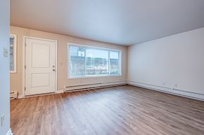 Seattle apartment for rent - an empty living room with wood flooring and a window