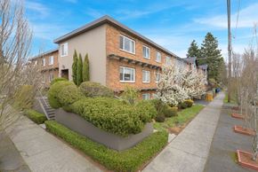 Seattle apartment for rent - the front of a building with a sidewalk and hedges