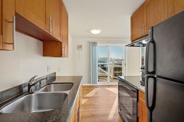 Seattle apartment for rent - a kitchen with stainless steel appliances and wooden cabinets and a door to a balcony