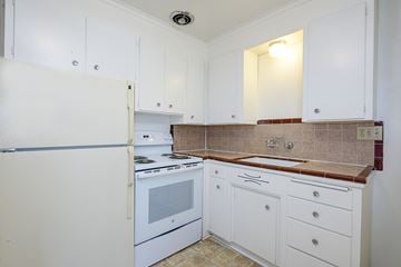 Seattle apartment for rent - a kitchen with white appliances and white cabinets