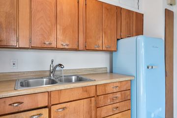 Seattle apartment for rent - a kitchen with wooden cabinets and a blue refrigerator