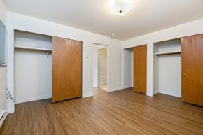 Seattle apartment for rent - a living room with wood flooring and white walls and wooden doors