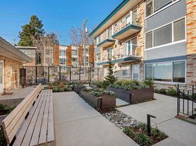 Seattle apartment for rent - a yard with a wooden bench in front of a building