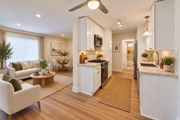 Ventura townhouse for rent - A modern kitchen with white cabinets and a wooden floor.