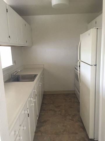 Kapolei apartment for rent - A white kitchen with a sink and a refrigerator.