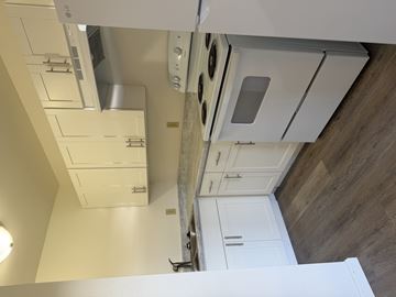 Kahului apartment for rent - A kitchen with white cabinets and a stainless steel range hood.