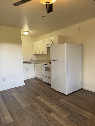 Kahului apartment for rent - A white refrigerator in a kitchen with wooden floors.
