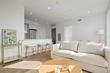 Los Angeles apartment for rent - A modern living room with a white sofa and a yellow bar cart.