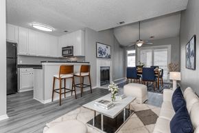 Dallas apartment for rent - A modern kitchen with white cabinets and a bar area.
