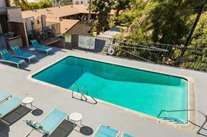 Van Nuys apartment for rent - a pool is shown at a hotel with blue chairs