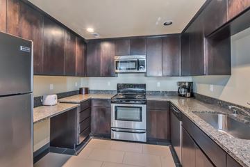 Olympia apartment for rent - A modern kitchen with dark brown cabinets and stainless steel appliances.