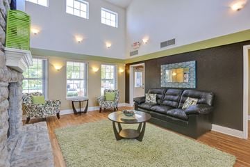 Fort Collins apartment for rent - A living room with a black couch and a fireplace.