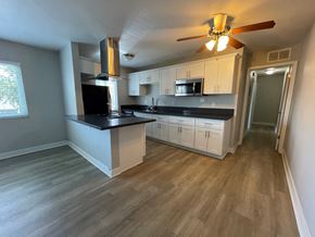 Woodland Hills apartment for rent - A kitchen with a black countertop and white cabinets.
