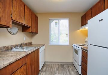 Everett apartment for rent - A kitchen with wooden cabinets and white appliances.