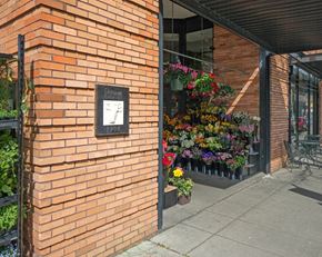 Portland apartment for rent - A brick wall with a plaque and a hanging flower basket.