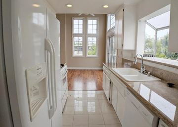 Los Angeles apartment for rent - A white refrigerator is in a kitchen with a sink and a window.