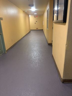 Los Angeles apartment for rent - A long, narrow hallway with a green door on the left and a window on the right.