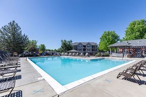 Longmont apartment for rent - A large outdoor swimming pool surrounded by lounge chairs.