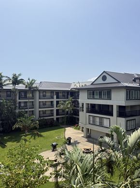 Kahului apartment for rent - A large white building with a balcony and a patio with a swing set.