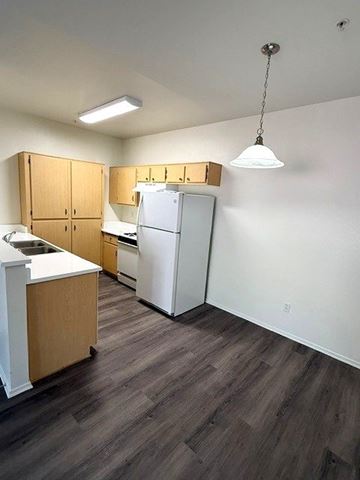 Simi Valley apartment for rent - A kitchen with wooden cabinets and a white refrigerator.