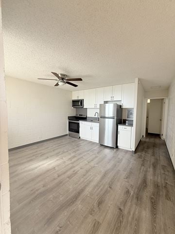 Waipahu apartment for rent - A kitchen with white cabinets and a refrigerator.