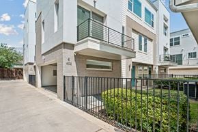 Dallas townhouse for rent - A modern two-story building with a balcony and a black fence in front.