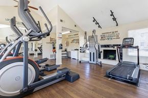Bedford apartment for rent - a gym with cardio equipment and a fireplace