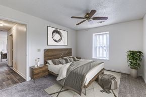 Central City apartment for rent - A bedroom with a bed, nightstand, and a ceiling fan.