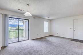Central City apartment for rent - A spacious room with a sliding glass door leading to a balcony.