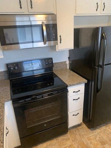 Redondo Beach apartment for rent - A black stove and oven in a kitchen with white cabinets.