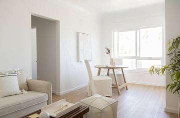Hollywood apartment for rent - A living room with a couch, chair, and a table with a box on it.