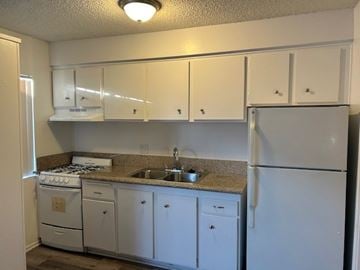 Torrance apartment for rent - A kitchen with white cabinets and appliances.