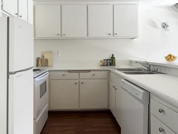 Sherman Oaks apartment for rent - a kitchen with white cabinets and a sink and a refrigerator