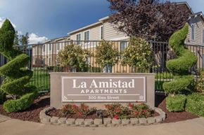Mendota apartment for rent - The image shows a sign for La Amistad Apartments with a building in the background.