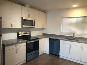 Milpitas apartment for rent - A kitchen with white cabinets and a black dishwasher.