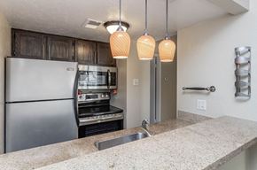 Dallas apartment for rent - A kitchen with a stainless steel refrigerator and a built-in oven.