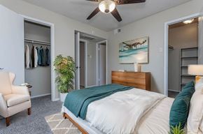 Dallas apartment for rent - A bedroom with a bed, chair, and painting on the wall.