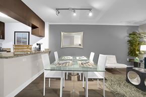Encino apartment for rent - A modern dining room with a glass table and white chairs.