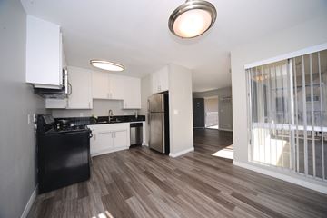 Sherman Oaks apartment for rent - a kitchen and living room with white cabinets and a stainless steel refrigerator