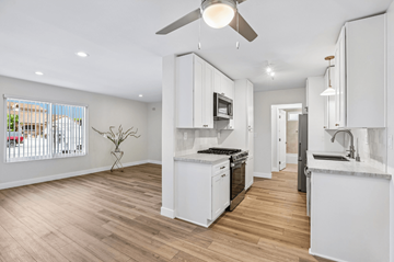 Ventura townhouse for rent - A modern kitchen with white cabinets and a wooden floor.