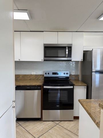 Honolulu apartment for rent - A kitchen with a stove top oven and a microwave above it.